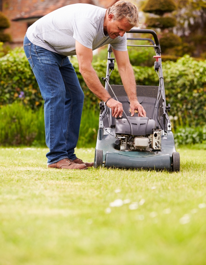 Réparation de tondeuse à gazon par un particulier dans un jardin